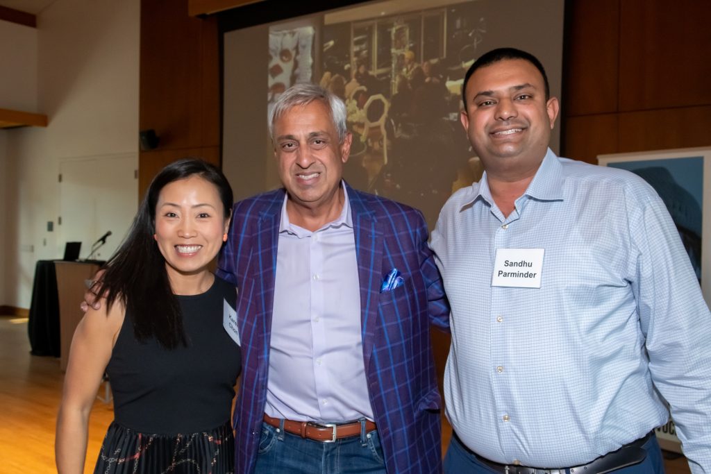 Honoree Neel Chatterjee smiling with two event guests