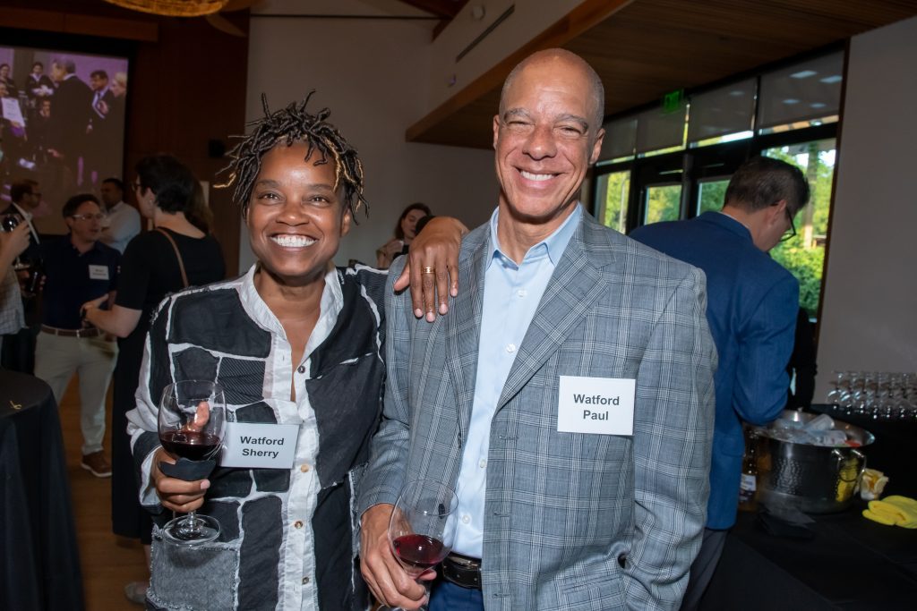 Two event guests smile and pose together