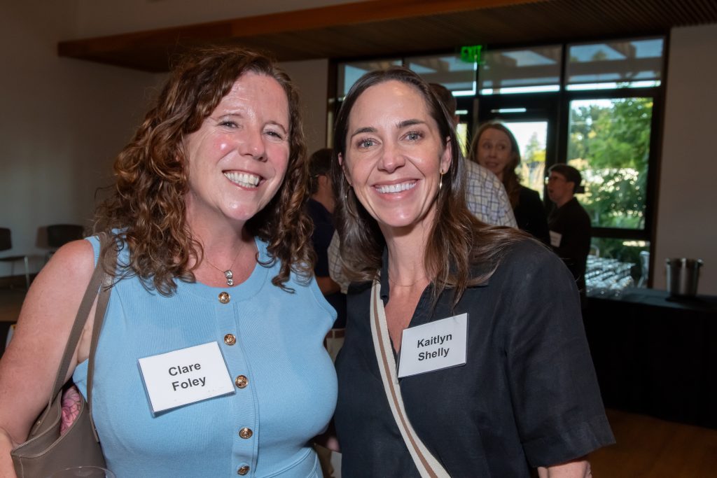 Two event guests smile and pose together