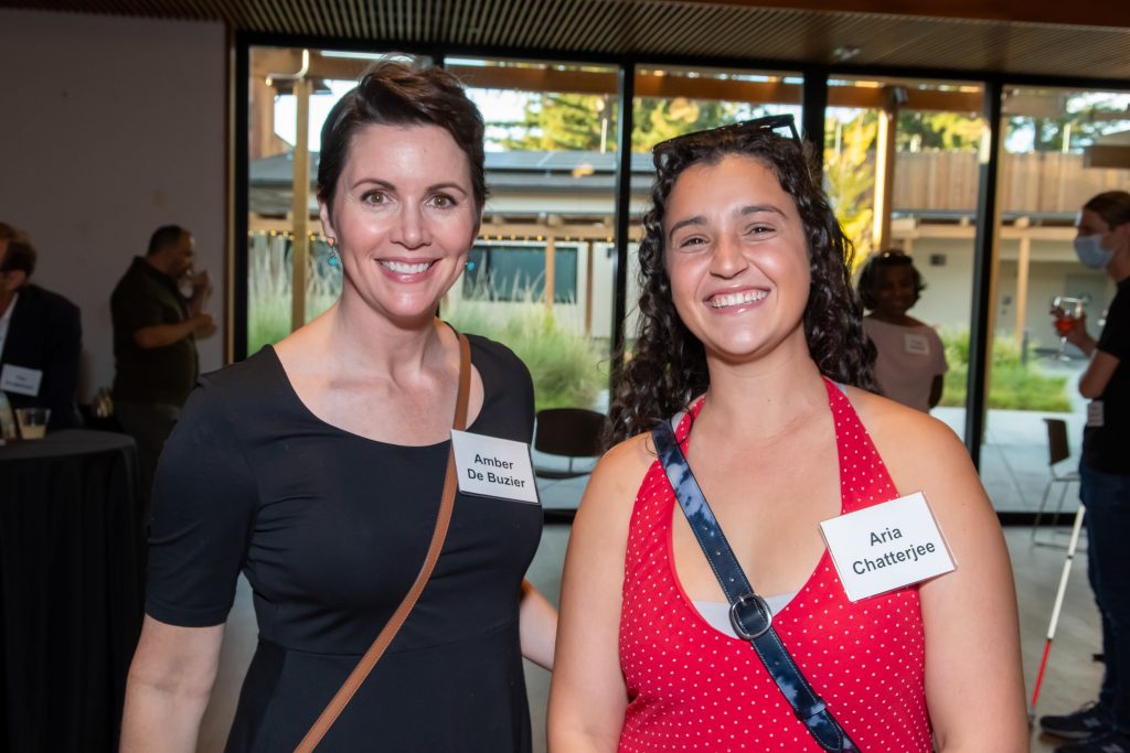 Two event guests smile and pose together