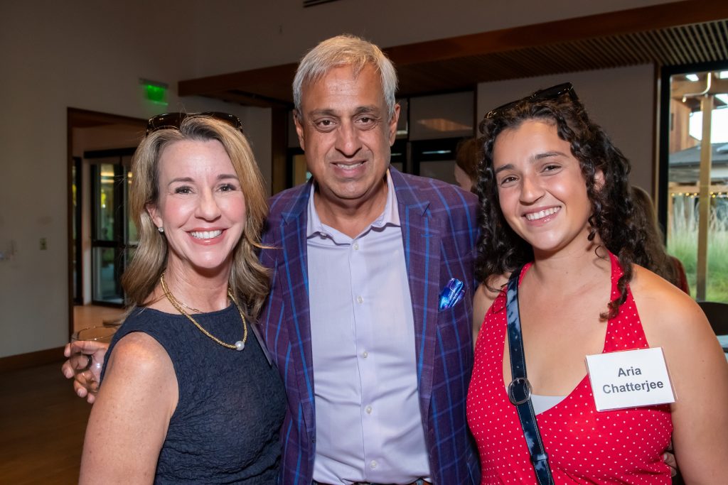 Honoree Neel Chatterjee smiling with two event guests