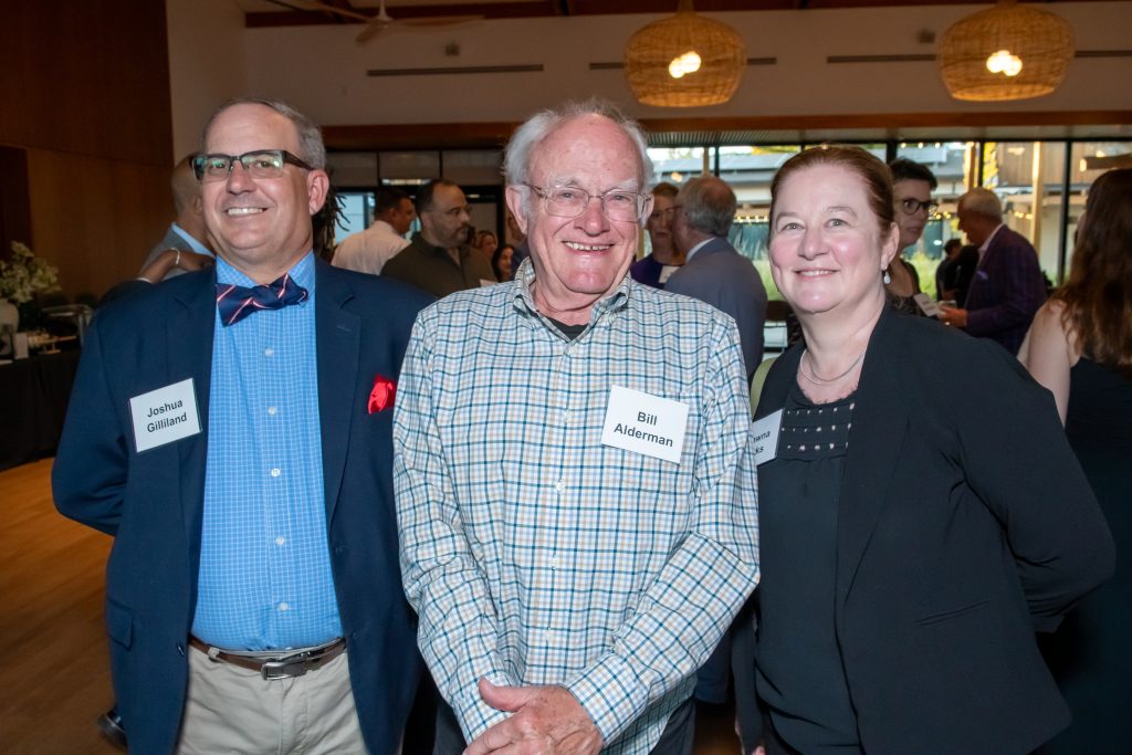 DRA's Shawna Parks and Advisor Bill Alderman smiling with an event guest