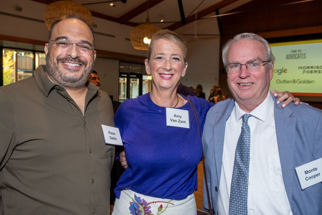 Three event guests smiling together