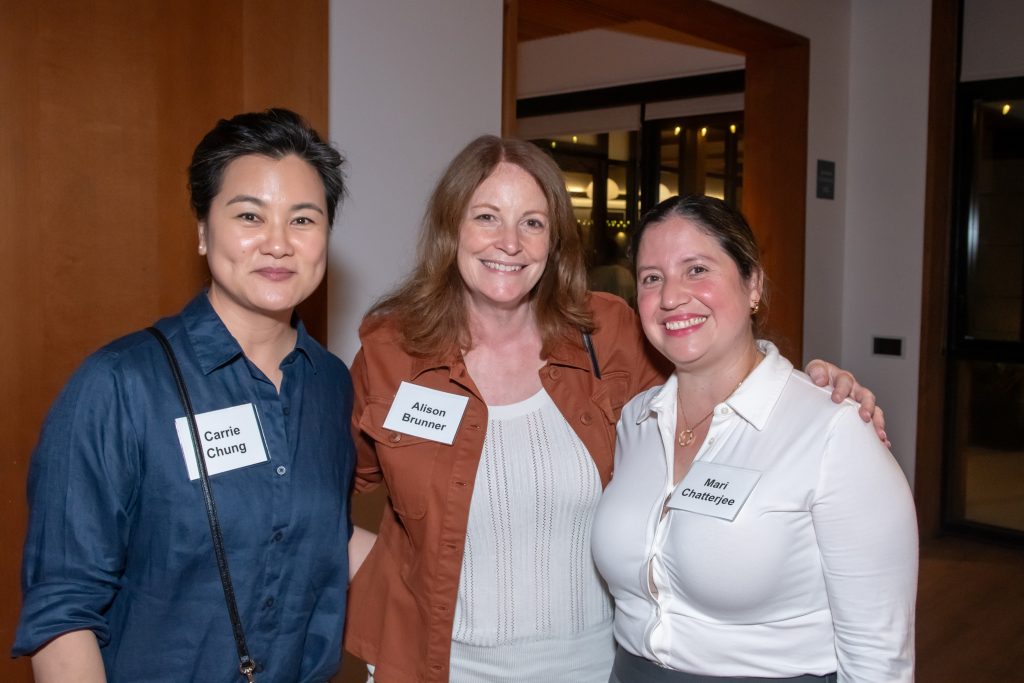 Three event guests smiling together